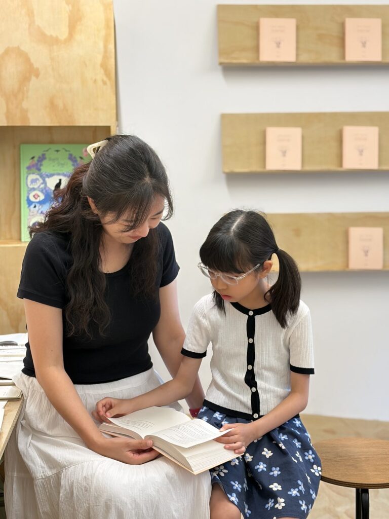 2026년 8월 22일 소복이 작가 북토크 — 『연이 이야기』 책이 나무 책상 위에 놓여 있어요
