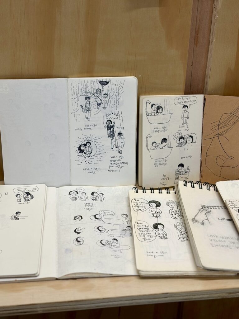 2026년 8월 22일 소복이 작가 북토크 — 작가가 책방 한쪽에서 그림 작업을 하고 있어요
