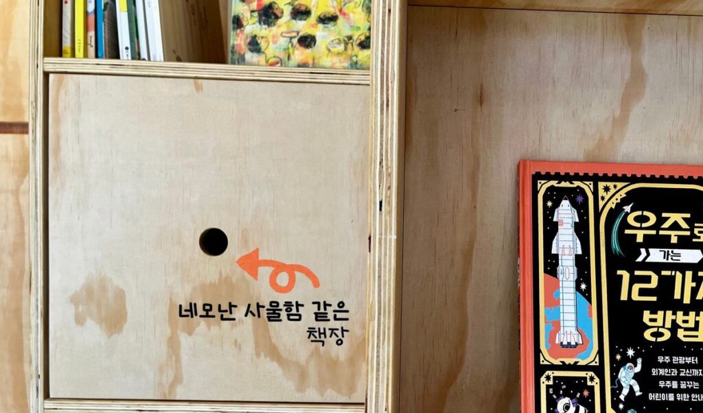 책방에 반영된 모습 — 네모난 사물함 같은 책장